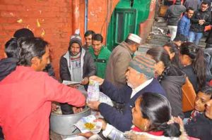 भोले नाथ का प्रसाद ग्रहण करते लोग